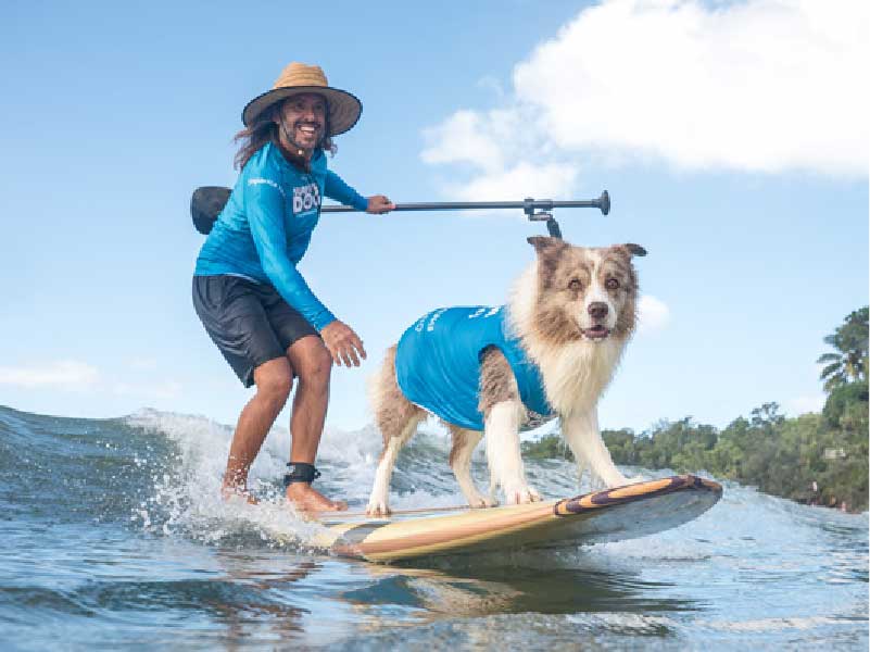 Loui, the 2026 Surfing Dog Champion, with his handler